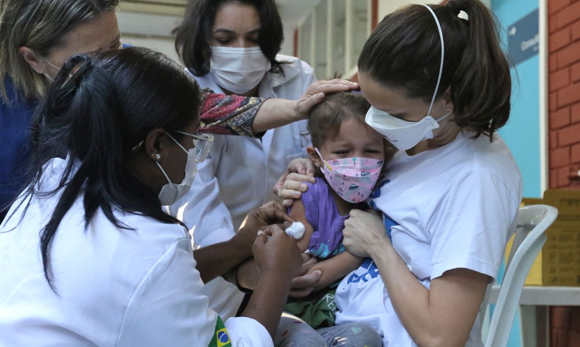 A menina Clarice Moretti, 4 anos, toma sua primeira dose de vacina contra a Covid-19  no Centro Municipal de Saúde Píndaro de Carvalho Rodrigues, na Gávea, zona sul da cidade. A cidade do Rio inicia hoje(15) a vacinação de crianças de 4 anos de idade contra a covid-19.